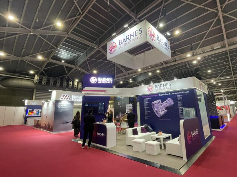 A purple and white exhibition MRO Singapore sign, illuminated displays and meeting seating.